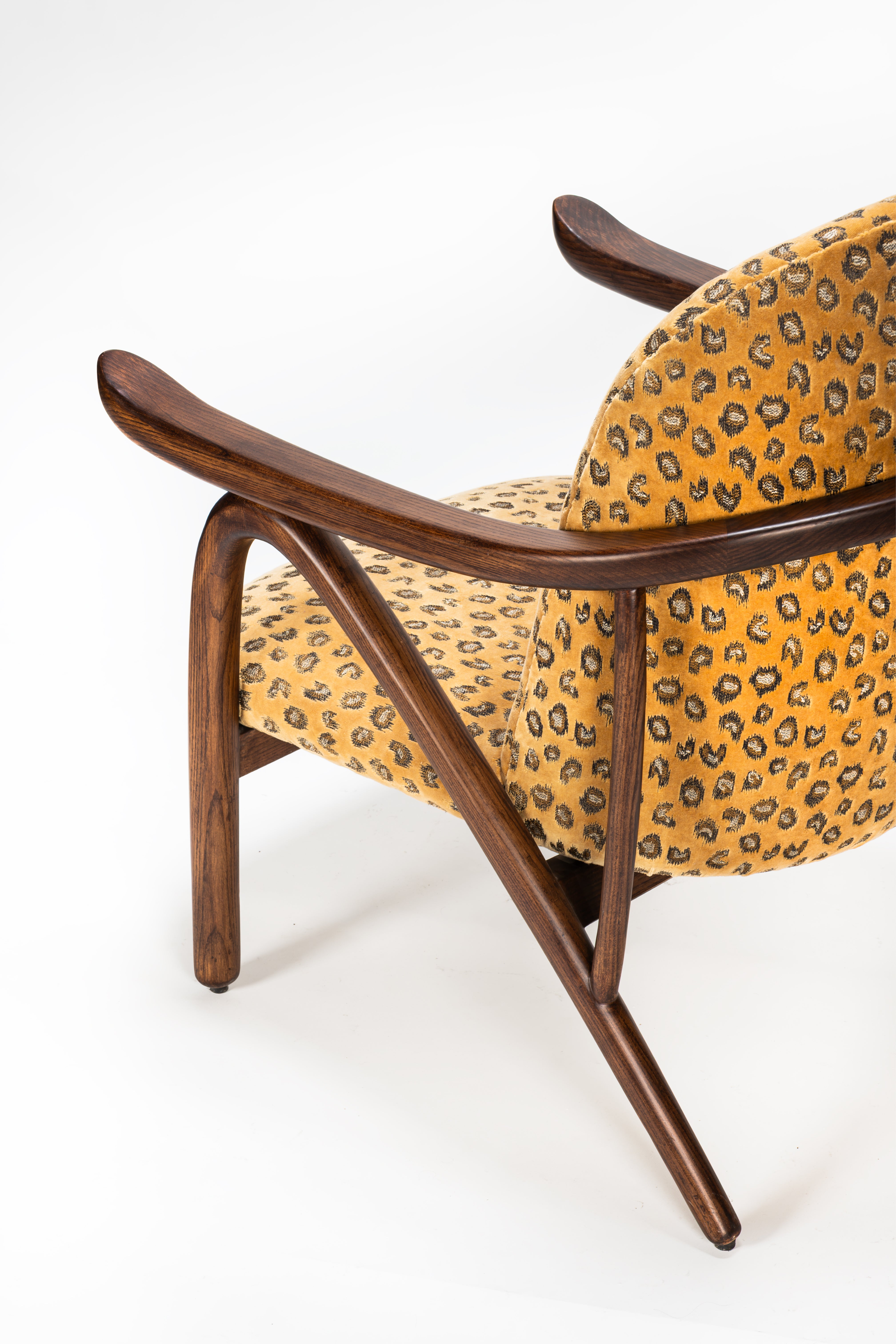 Chair with wooden frame and leopard print fabric on a white background